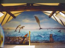 Dolfijnen van Zuid-Afrika, woelijk zee, papegaai Ara op muur in valse stenen.