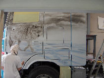 Versieringswerk van een vrachtwagen tijdens het uitvoeren met een verfspuit..
